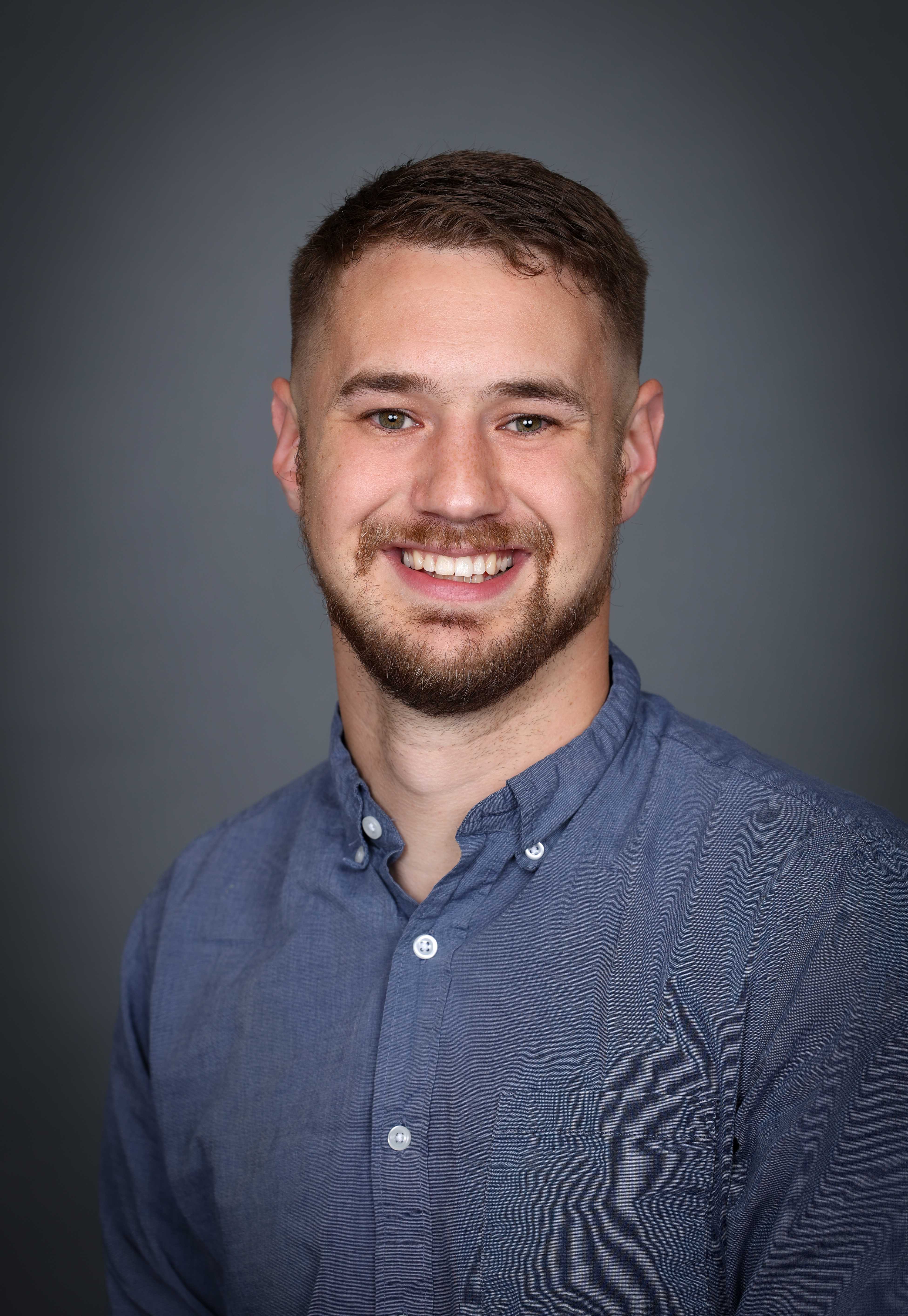 photo of Caleb Patterson wearing a blue button up shirt